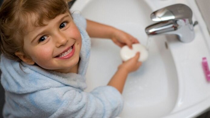 Child washes hands with soap to prevent worms